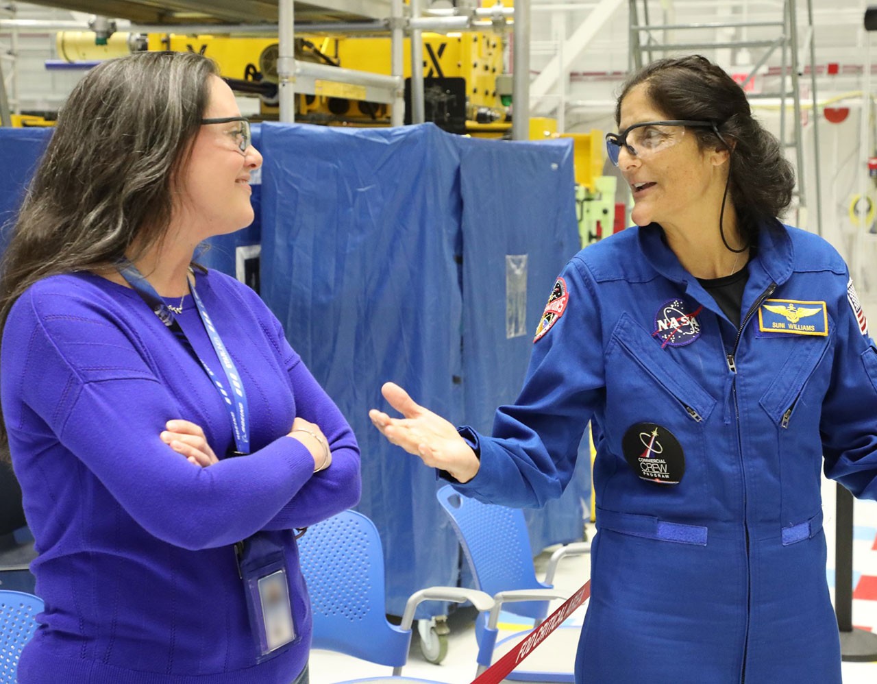 Dee Dobson talks with NASA astronaut Suni Williams in the factory at the Commercial Crew and Cargo Processing Facility.