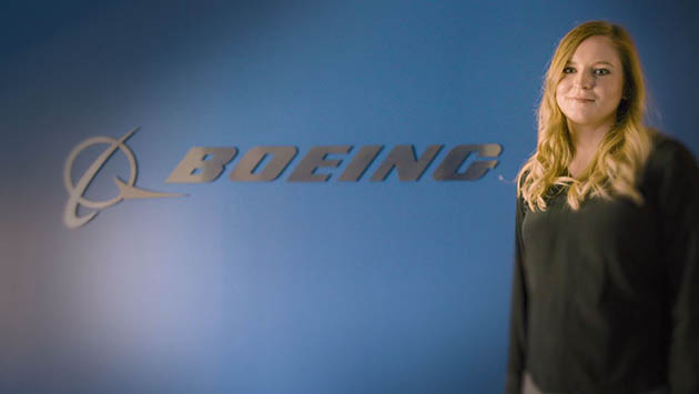 Emily Schnieders standing in front of Boeing logo on wall